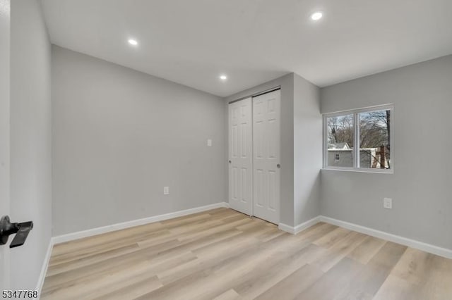 unfurnished bedroom with recessed lighting, light wood finished floors, and baseboards