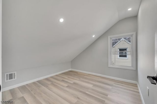 bonus room featuring visible vents, baseboards, recessed lighting, vaulted ceiling, and light wood-style flooring