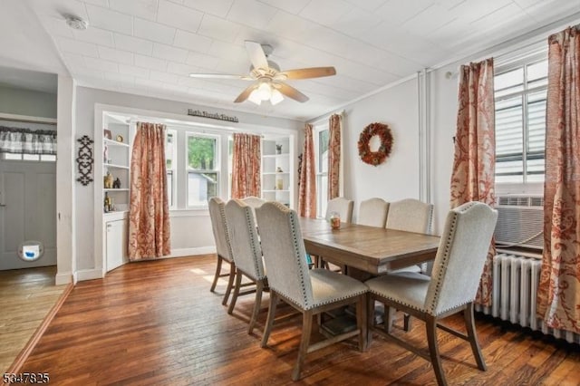 dining room featuring ceiling fan, baseboards, wood-type flooring, and radiator heating unit