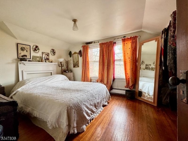 bedroom featuring baseboard heating, wood-type flooring, and lofted ceiling