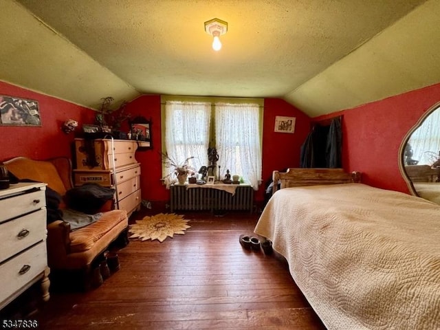 bedroom with radiator heating unit, hardwood / wood-style flooring, and lofted ceiling