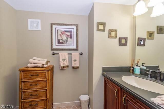 bathroom with tile patterned floors, baseboards, and vanity