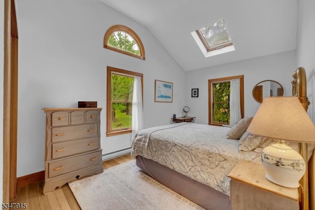 28 Academy St, Califon Boro, NJ 07830 - bedroom with a skylight, light wood-type flooring, multiple windows, a baseboard heating unit, and high vaulted ceiling