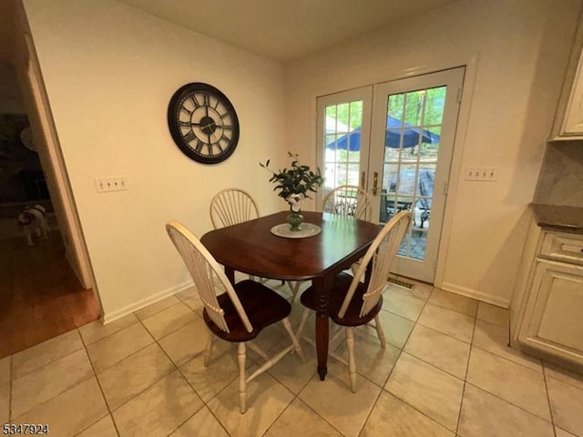 dining room with light tile patterned floors, baseboards, and french doors