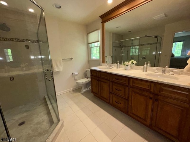 bathroom with a sink, a shower stall, toilet, and double vanity