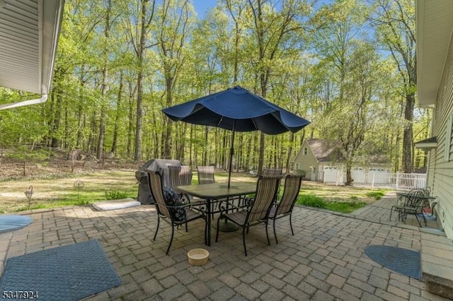 view of patio featuring a grill, fence, and outdoor dining space