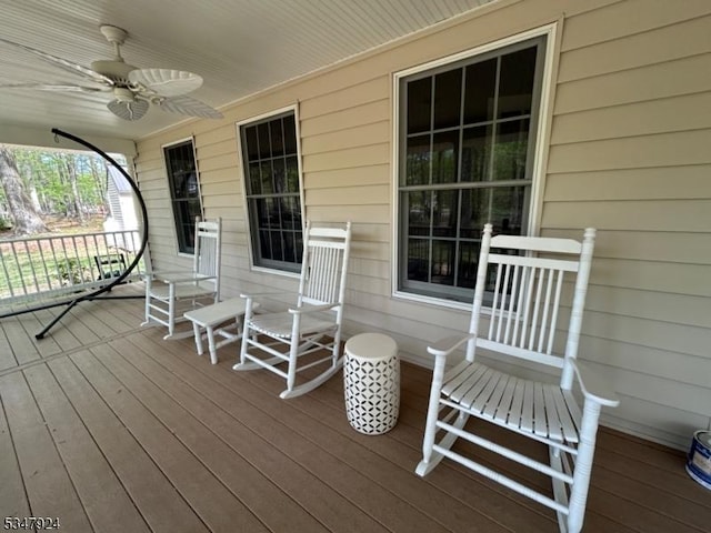 wooden terrace featuring a porch and a ceiling fan