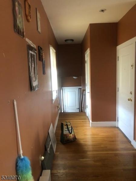 hallway featuring baseboards and wood finished floors