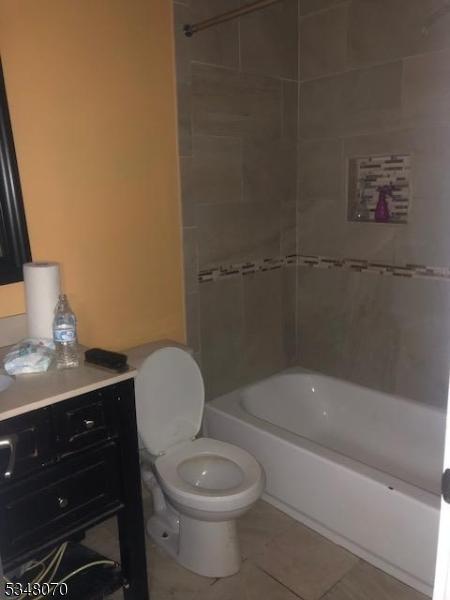 bathroom with toilet, bathtub / shower combination, tile patterned flooring, and vanity
