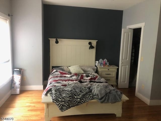 bedroom featuring baseboards and wood finished floors