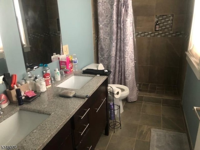 full bath with toilet, tiled shower, a sink, and tile patterned flooring