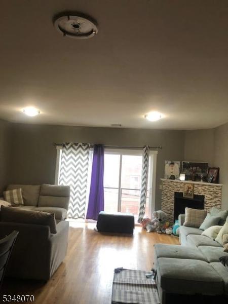 living room with plenty of natural light, a fireplace, and wood finished floors