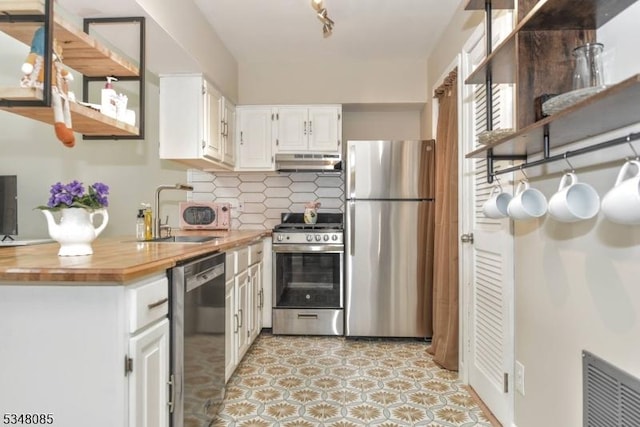 3 Davos Dr Unit 6, Vernon Twp, NJ 07462 - kitchen with tasteful backsplash, white cabinetry, under cabinet range hood, appliances with stainless steel finishes, and a sink