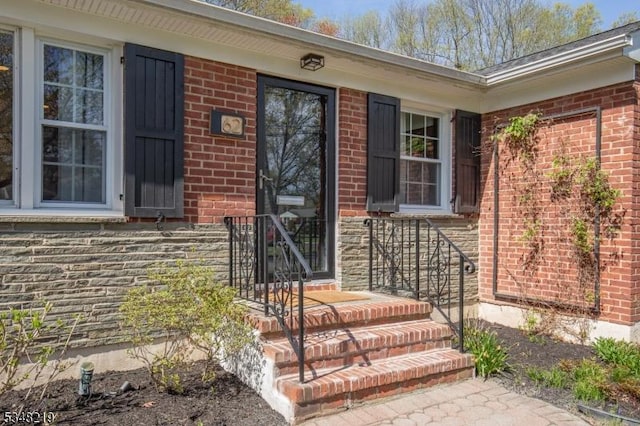view of exterior entry featuring brick siding