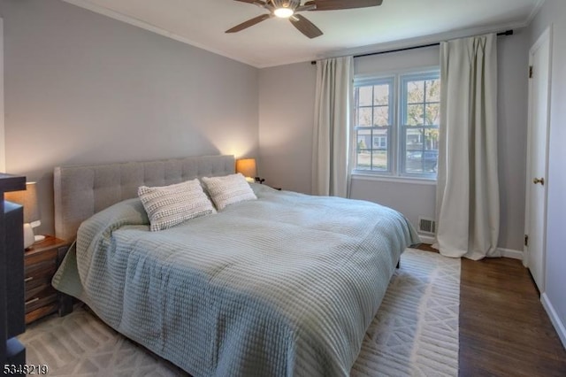 bedroom featuring crown molding, light wood finished floors, visible vents, and baseboards