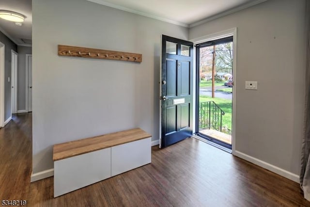 foyer entrance with wood finished floors, ornamental molding, and baseboards