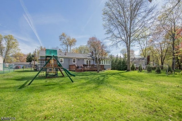 exterior space featuring fence, a wooden deck, and a playground