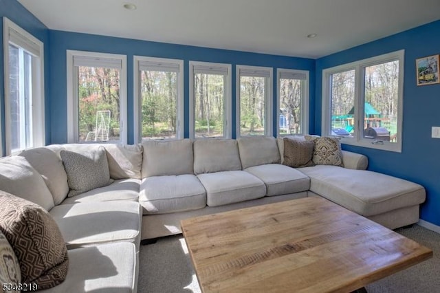 living room featuring baseboards, carpet floors, and plenty of natural light