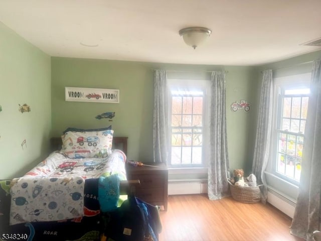 bedroom featuring wood finished floors and visible vents