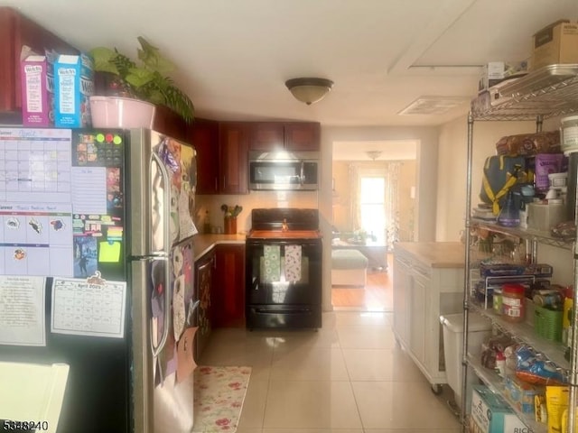 kitchen with light tile patterned flooring, stainless steel appliances, and light countertops
