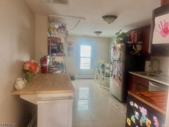 kitchen with visible vents, a sink, light tile patterned flooring, a baseboard heating unit, and appliances with stainless steel finishes
