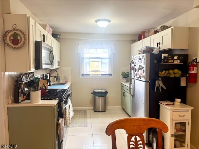 kitchen featuring stainless steel appliances, light countertops, a sink, and light tile patterned floors