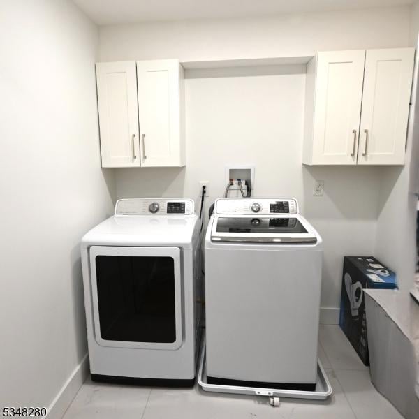 laundry room featuring cabinet space, washing machine and clothes dryer, and baseboards