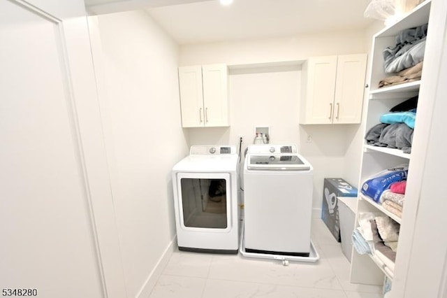 clothes washing area featuring baseboards, marble finish floor, independent washer and dryer, and cabinet space