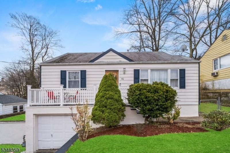 bungalow with a front lawn, fence, and an attached garage