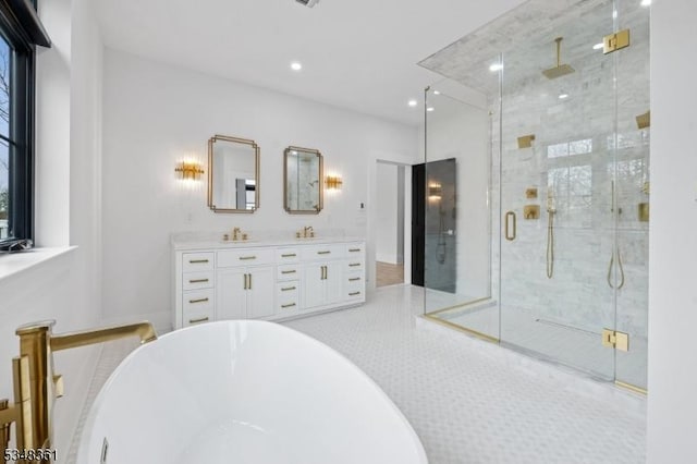 full bathroom with double vanity, a freestanding tub, a stall shower, and recessed lighting