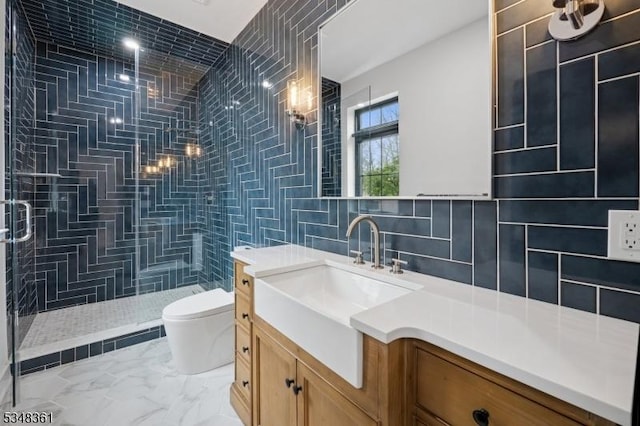 full bathroom with marble finish floor, toilet, tiled shower, and tile walls