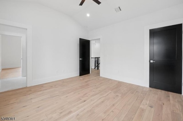 interior space with lofted ceiling, baseboards, visible vents, a ceiling fan, and wood finished floors