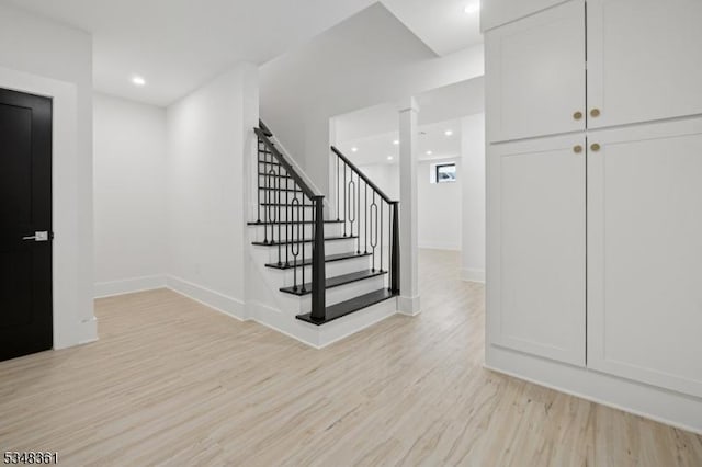 stairs featuring baseboards, wood finished floors, and recessed lighting