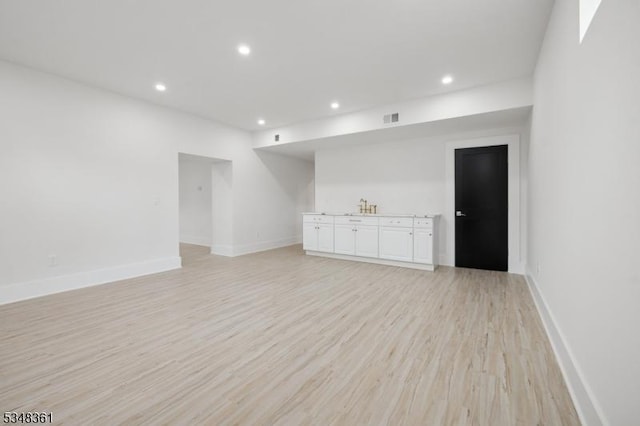 spare room featuring recessed lighting, baseboards, light wood finished floors, and visible vents