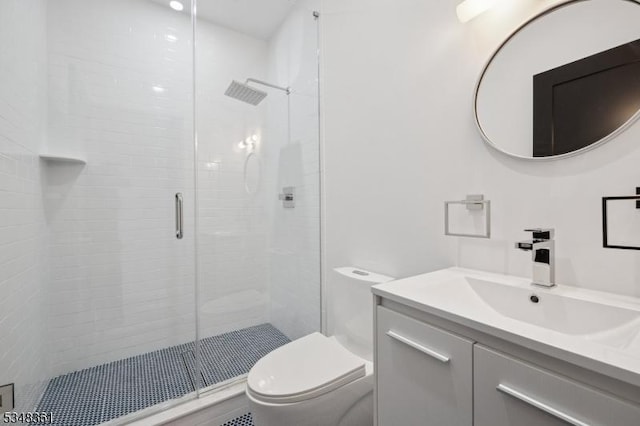 bathroom featuring a stall shower, toilet, and vanity