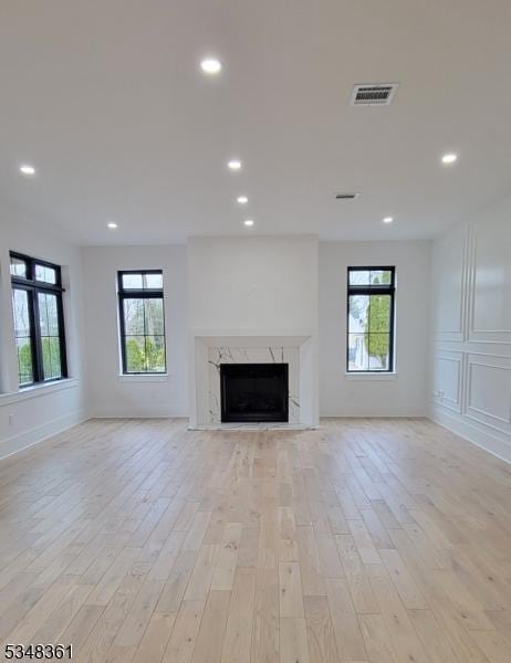 unfurnished living room with a wealth of natural light, visible vents, light wood-style floors, and recessed lighting
