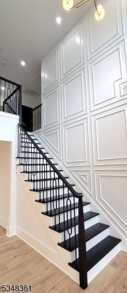 staircase with baseboards, wood finished floors, and recessed lighting