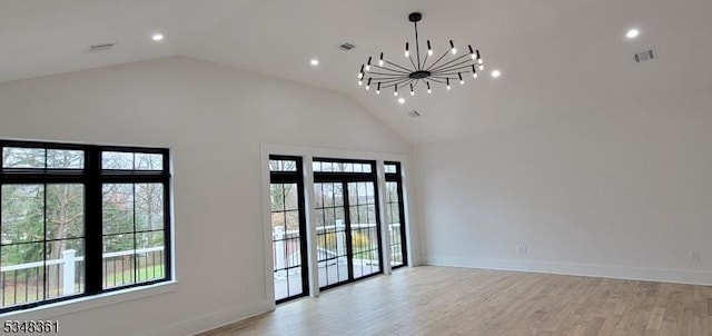 unfurnished room featuring a notable chandelier, high vaulted ceiling, light wood-style floors, and visible vents