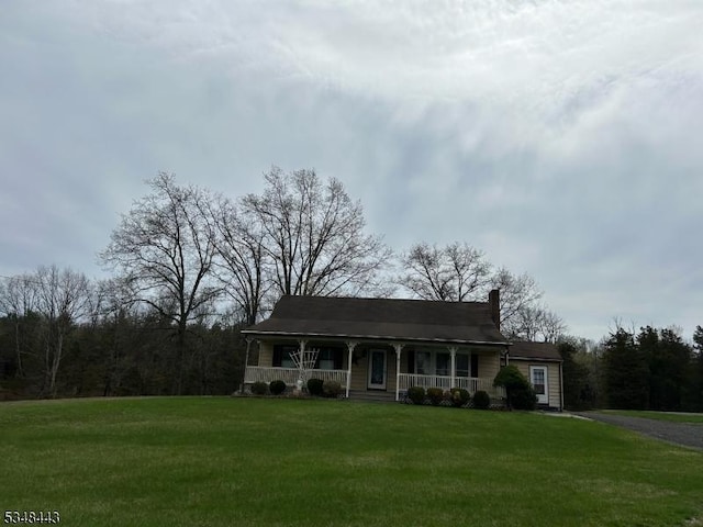 view of front of home with covered porch, a front yard, and aphalt driveway