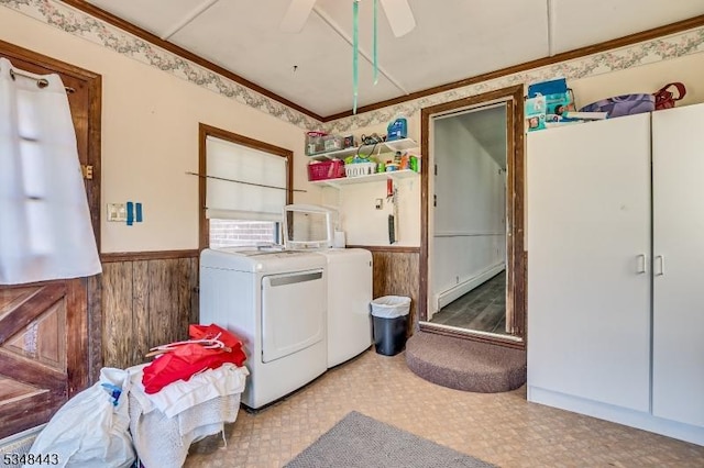 laundry room featuring washing machine and dryer, wooden walls, a wainscoted wall, and laundry area