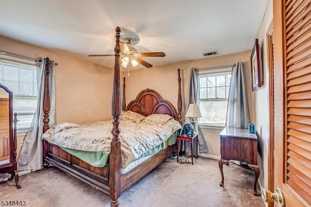 carpeted bedroom with visible vents, a ceiling fan, and baseboards