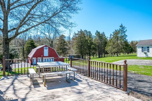 wooden deck with a lawn, an outbuilding, and a barn