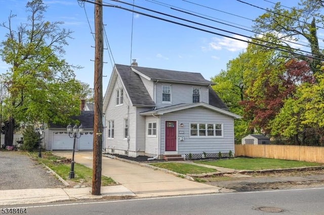 view of front of home featuring fence, a garage, entry steps, an outdoor structure, and driveway