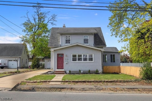 view of front of house with a front lawn, fence, driveway, and a chimney