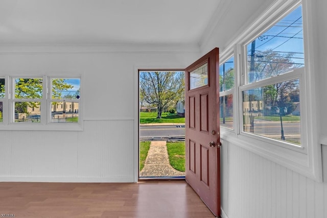 interior space featuring crown molding, a healthy amount of sunlight, and wood finished floors