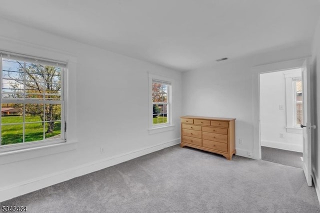 unfurnished bedroom featuring carpet floors, baseboards, and visible vents