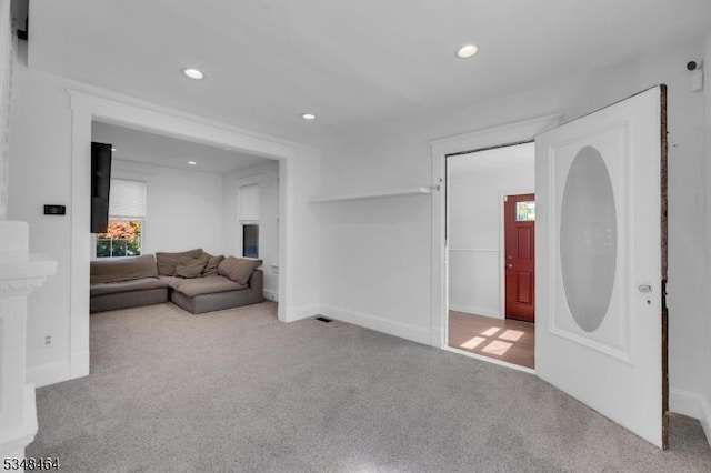 carpeted living area with recessed lighting and baseboards