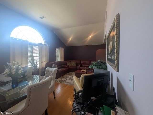 living room featuring wood finished floors and vaulted ceiling