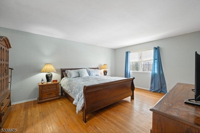 bedroom with baseboards and light wood finished floors