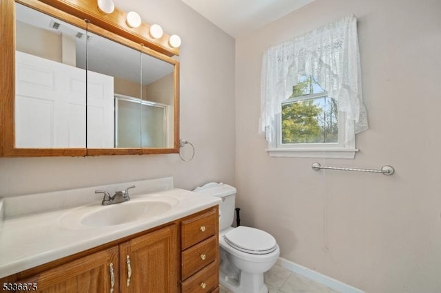 full bath featuring baseboards, toilet, vanity, a stall shower, and tile patterned flooring